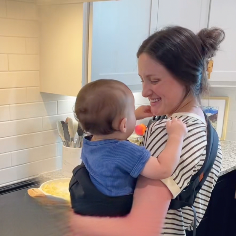 Parent cooking with baby in the sling