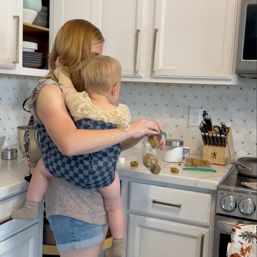 Parent baking with baby in the sling